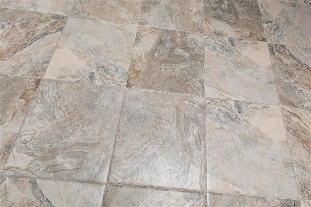 A close-up view of square, multi-toned brown and grey stone-look floor tiles — 4812 JASPER DRIVE UNIT 107, NEW PORT RICHEY, FL