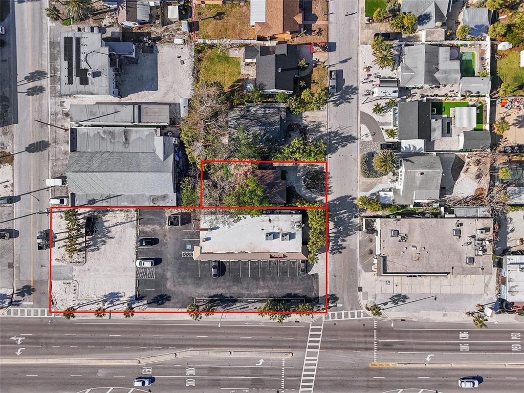 An aerial view shows a commercial building with a parking lot and an adjacent house — 420 77TH AVENUE, ST PETE BEACH, FL