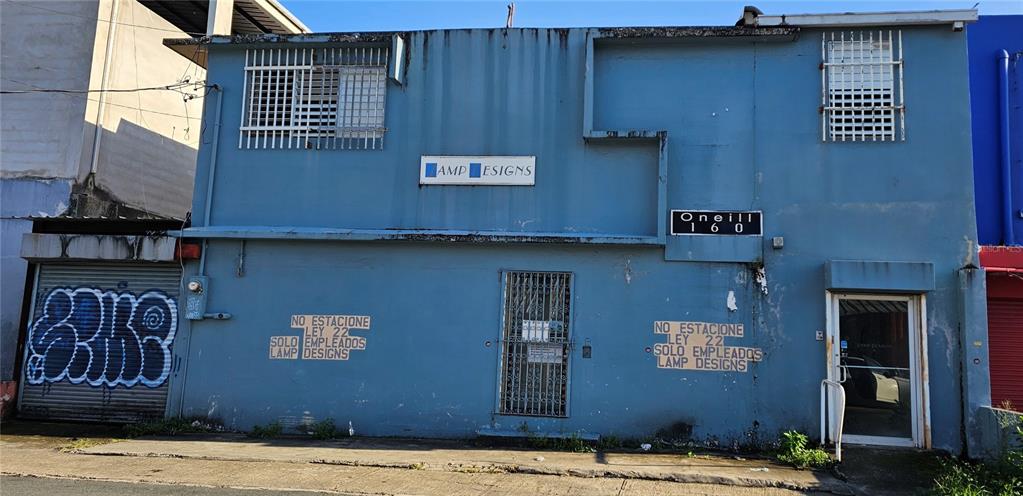 A two-story blue commercial building with a roll-up garage door and security bars on windows — 151 FD ROOSEVELT AVE. AVENUE, SAN JUAN, PR