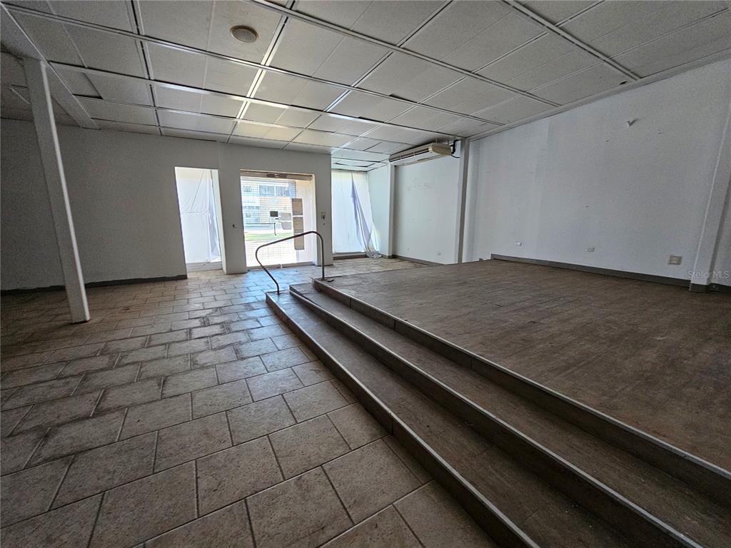 An empty commercial space features a raised wooden platform, tiled flooring, and a drop ceiling — 151 FD ROOSEVELT AVE. AVENUE, SAN JUAN, PR