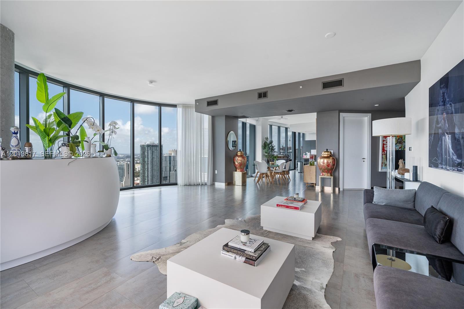 A modern living room with gray tile floors, floor-to-ceiling windows, and city views — 200 Biscayne Boulevard Way # 4902, Miami FL 33131, MIAMI, FL