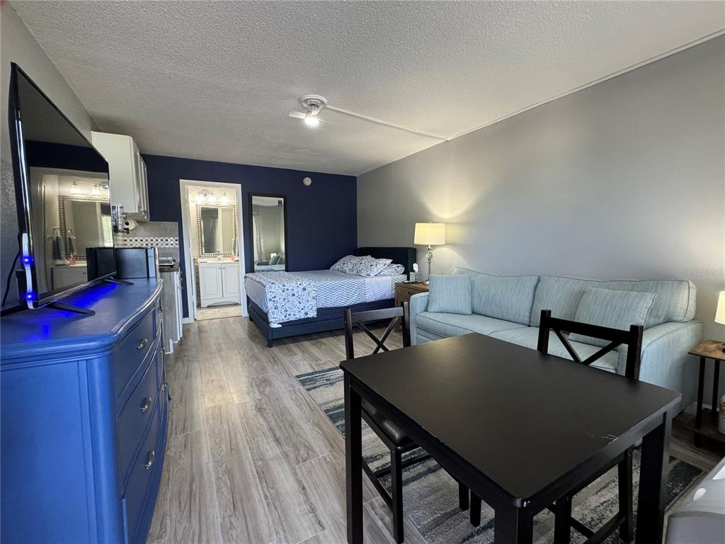 A studio apartment features a bed, a sofa, a dining table, and a blue dresser — 7150 N TAMIAMI TRAIL UNIT S-623, SARASOTA, FL
