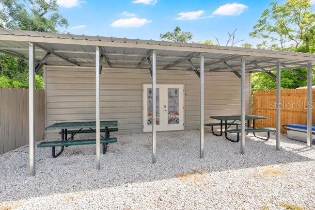 A covered outdoor patio area features two picnic tables on a gravel surface — 123 W RHODE ISLAND AVENUE, ORANGE CITY, FL