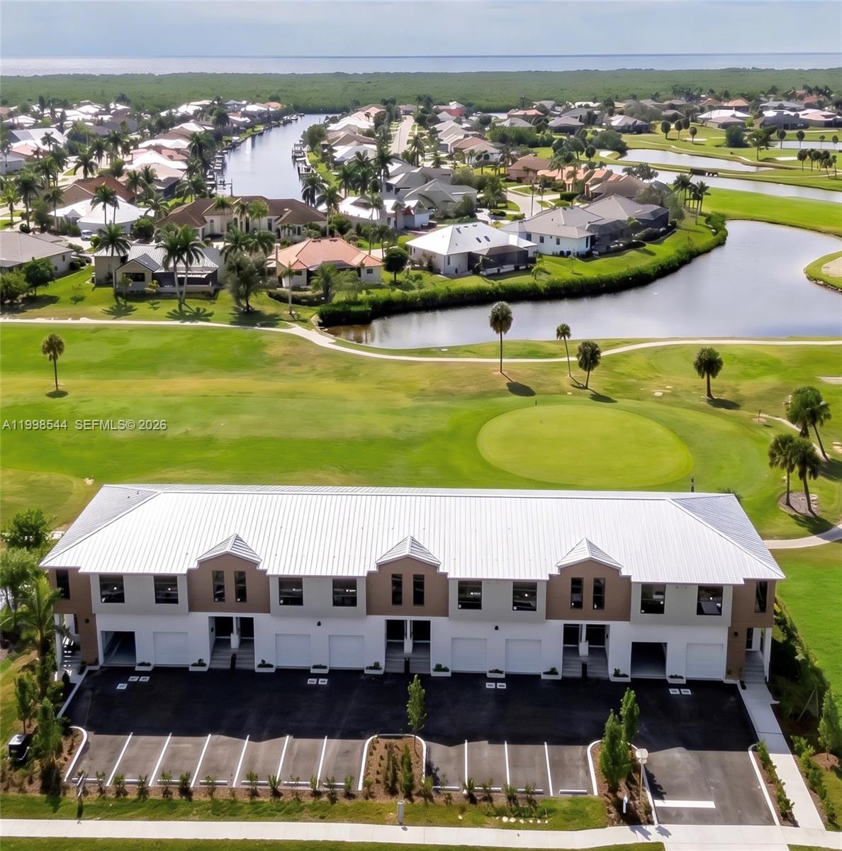 An aerial view shows a multi-unit townhouse building overlooking a golf course and water — 3609 Bal Harbor blvd, FL 33950, FL