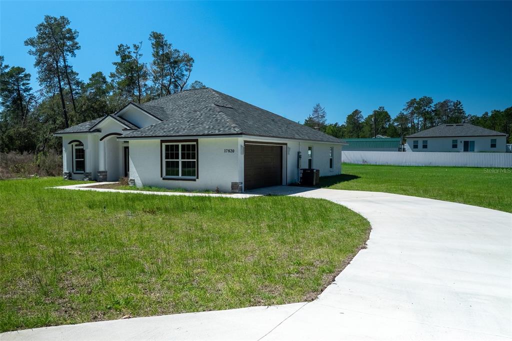 A single-story white house with a dark roof and a concrete driveway — 17820 SW 33RD TERRACE, OCALA, FL