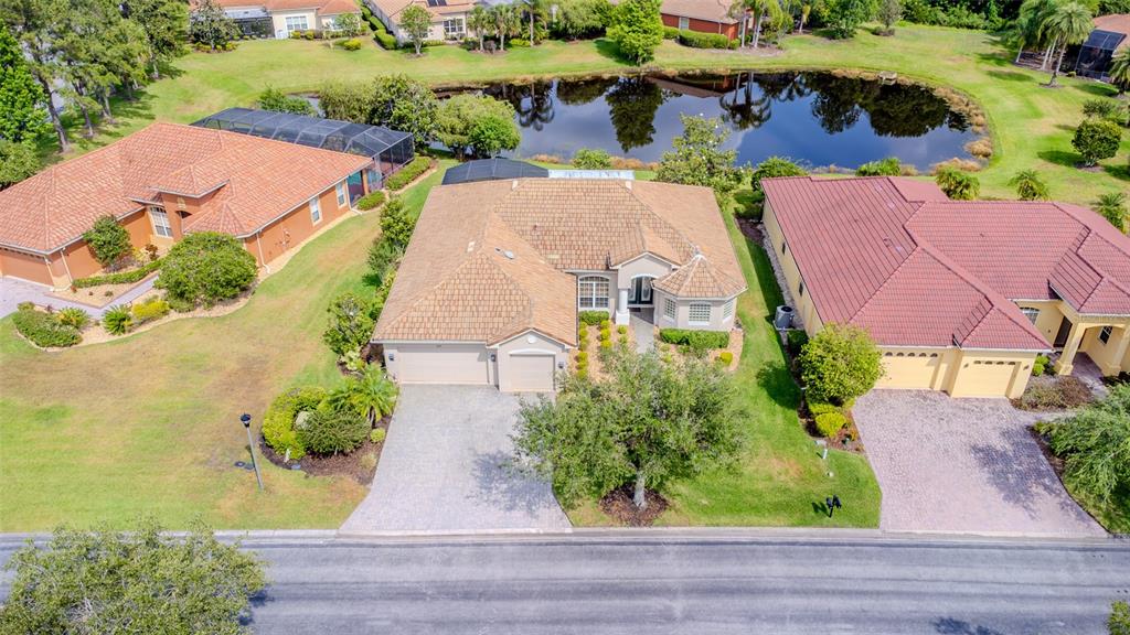 An aerial view shows a suburban house with a tan roof between two other homes — 537 MONTAGE LANE, KISSIMMEE, FL