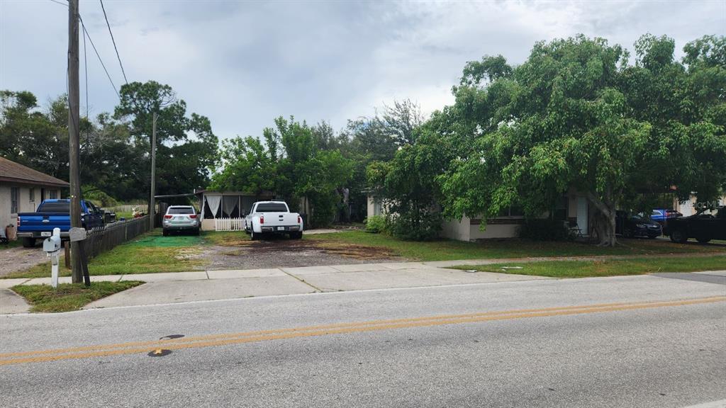A street-level view shows two single-story houses with driveways and parked vehicles under cloudy skies — 1114,1116,1118,1120&1128 WYATT  STREET, LARGO, FL