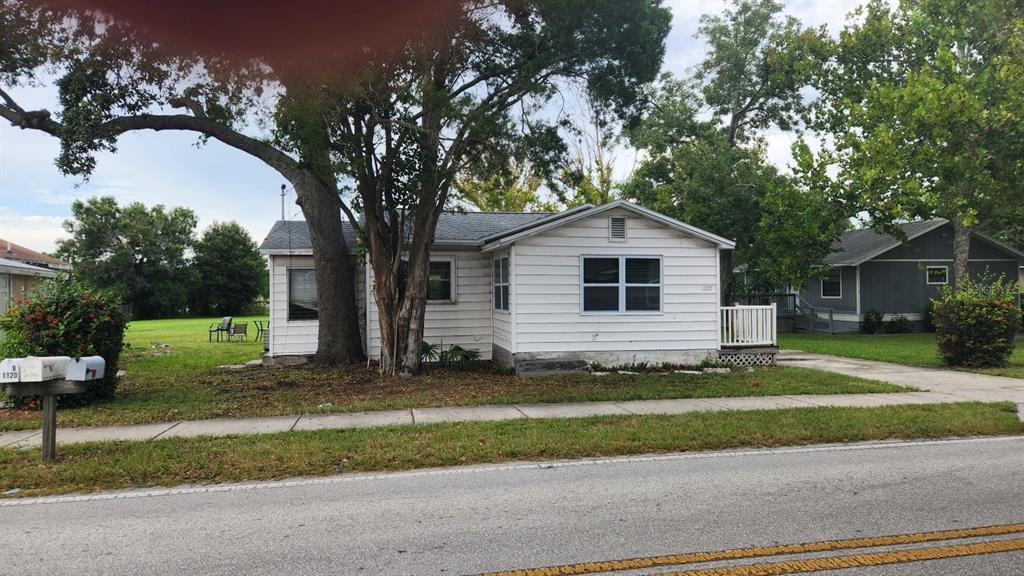 A white single-story house with a large tree in the front yard and a mailbox — 1114,1116,1118,1120&1128 WYATT  STREET, LARGO, FL