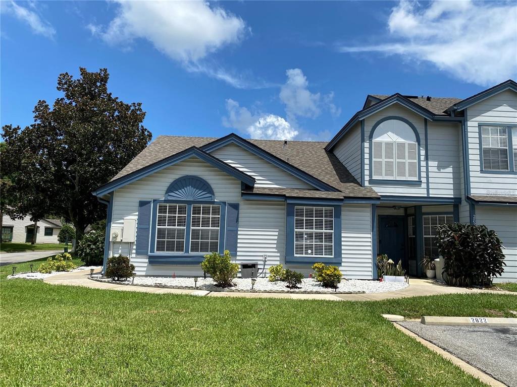 A two-story house with light siding, blue trim, and a white rock landscape bed — 2822 CANDELA COURT, APOPKA, FL