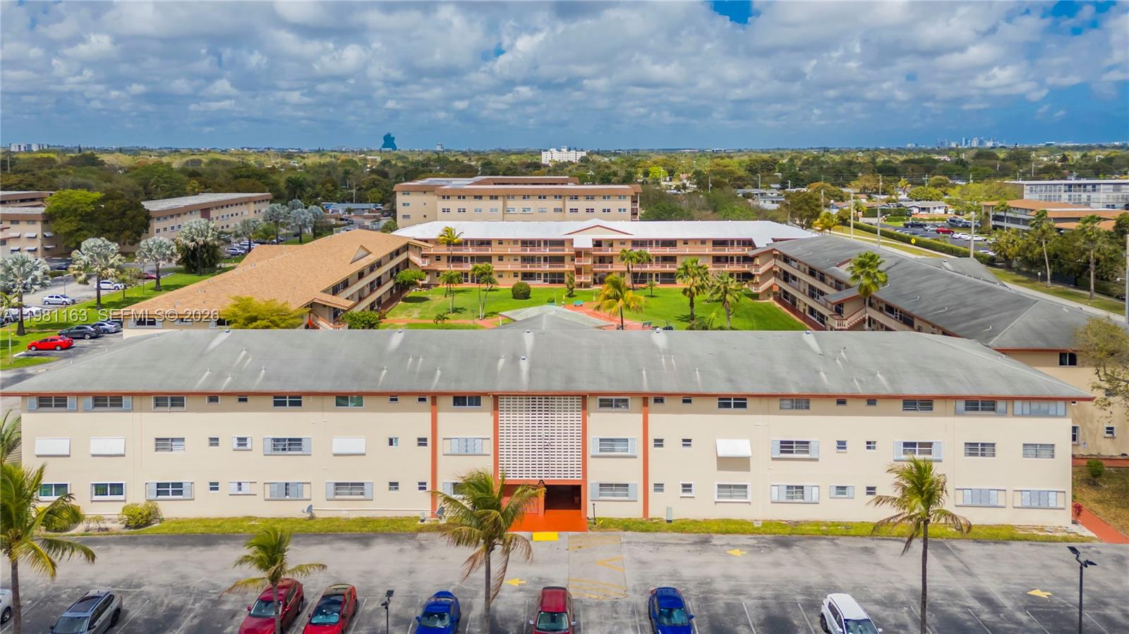 An aerial view shows a multi-story apartment complex with a central courtyard and parking lot — 5300 Washington St # A137, Hollywood FL 33021, HOLLYWOOD, FL