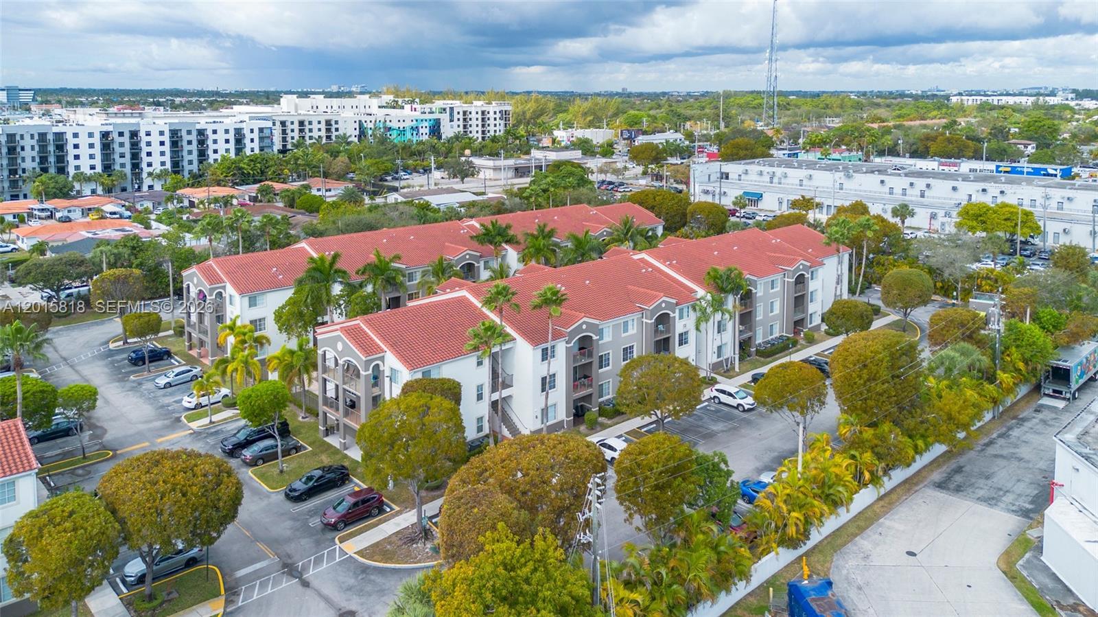 An aerial view shows a multi-story apartment complex with red tile roofs and parking lots — 6861 SW 44th St # 109, Miami FL 33155, MIAMI, FL