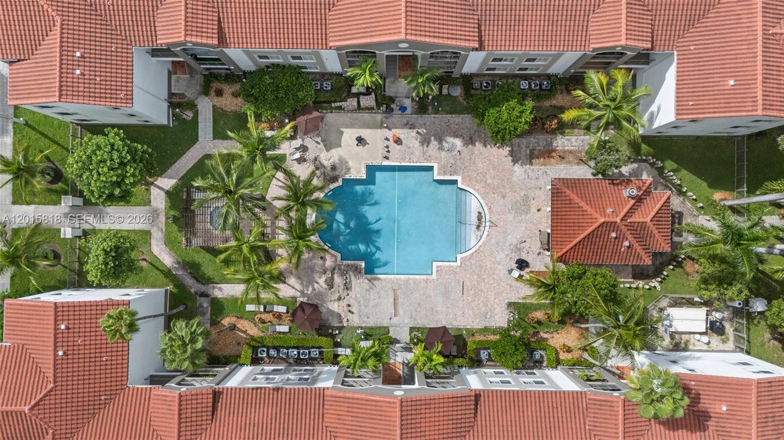 An aerial view shows a swimming pool surrounded by a patio, landscaping, and apartment buildings — 6861 SW 44th St # 109, Miami FL 33155, MIAMI, FL
