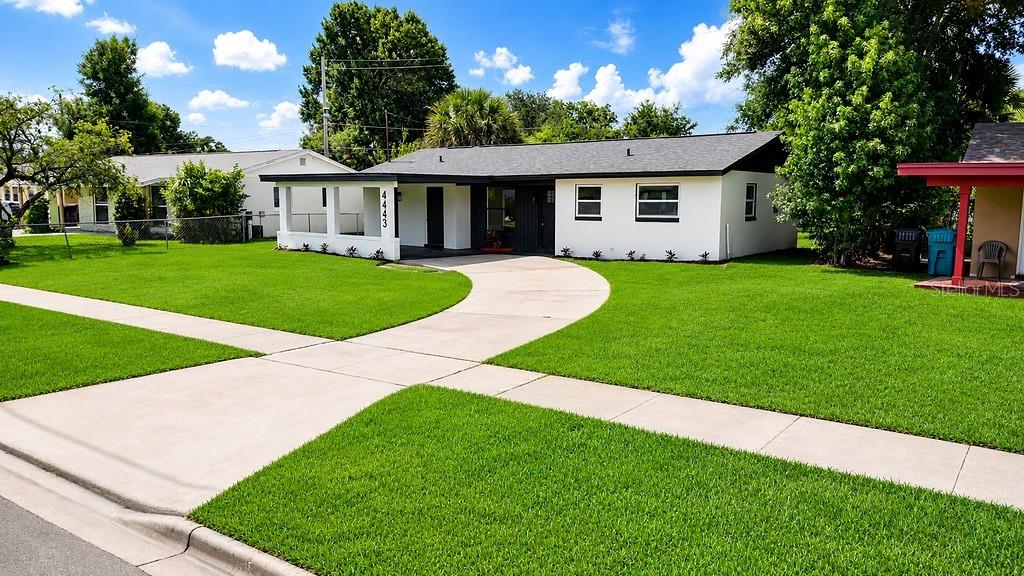 A white single-story house with a dark roof and a curved concrete driveway — 4443 KING COLE BOULEVARD, ORLANDO, FL