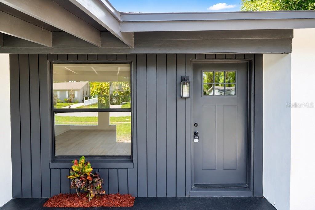 A dark gray exterior wall features a front door, a window, and a small plant — 4443 KING COLE BOULEVARD, ORLANDO, FL