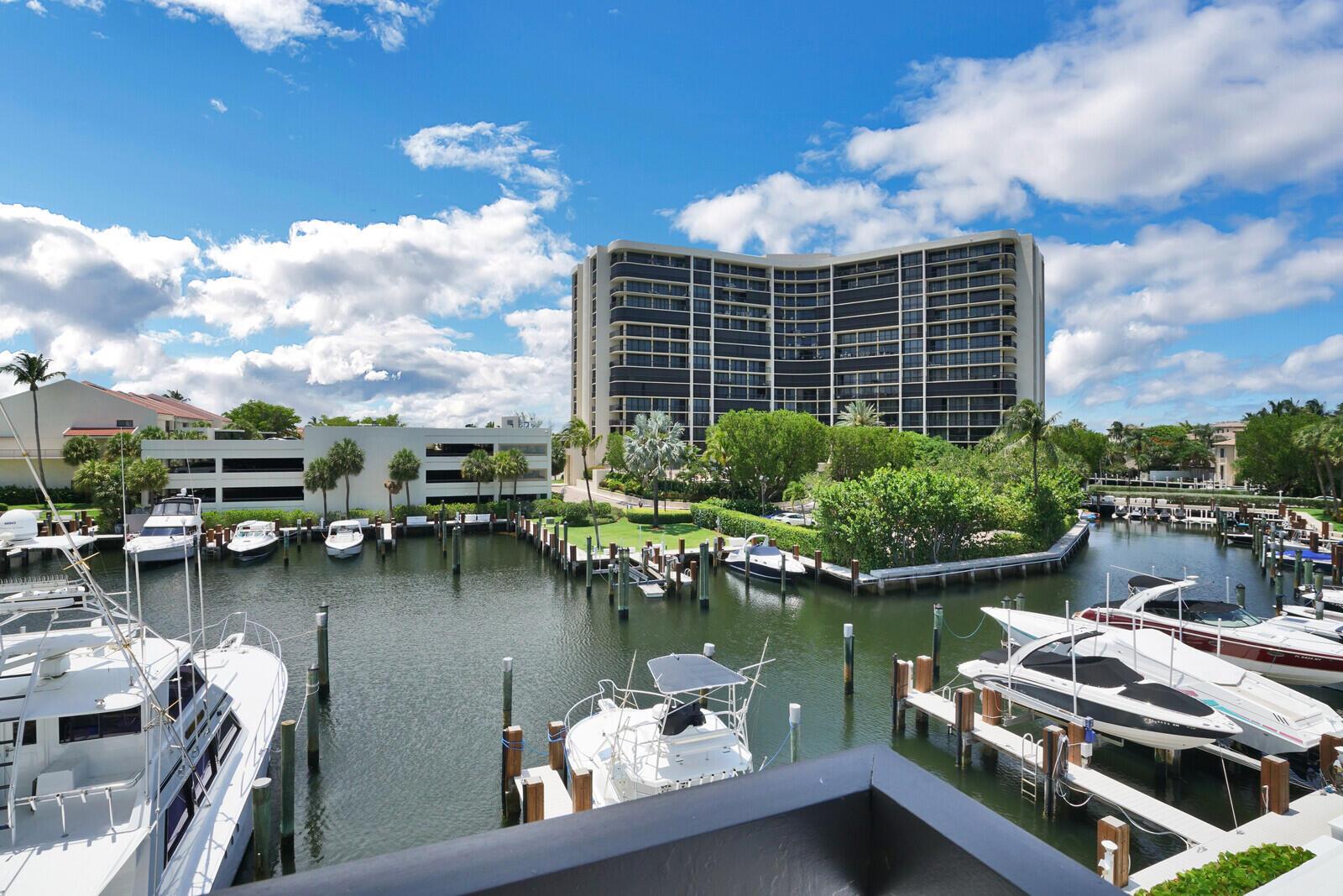 A view of a marina with several docked boats and a large apartment building behind — 4748 S Ocean Boulevard # a, Highland Beach FL 33487, HIGHLAND BEACH, FL