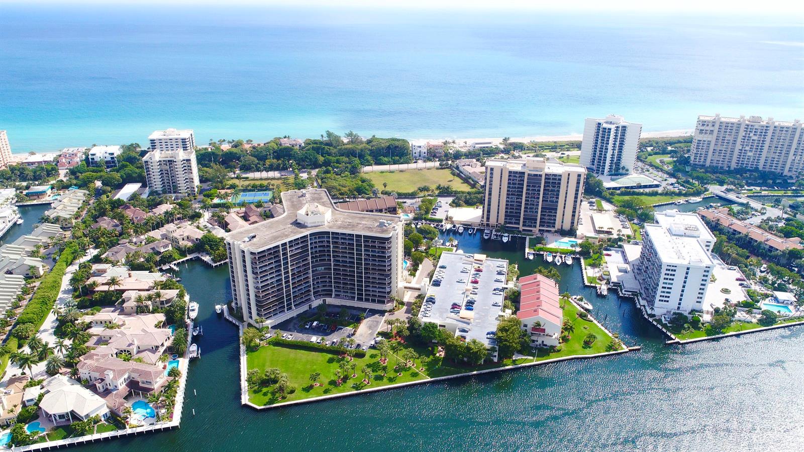 Aerial view of waterfront high-rise apartment buildings surrounded by canals and tropical landscaping — 4748 S Ocean Boulevard # a, Highland Beach FL 33487, HIGHLAND BEACH, FL