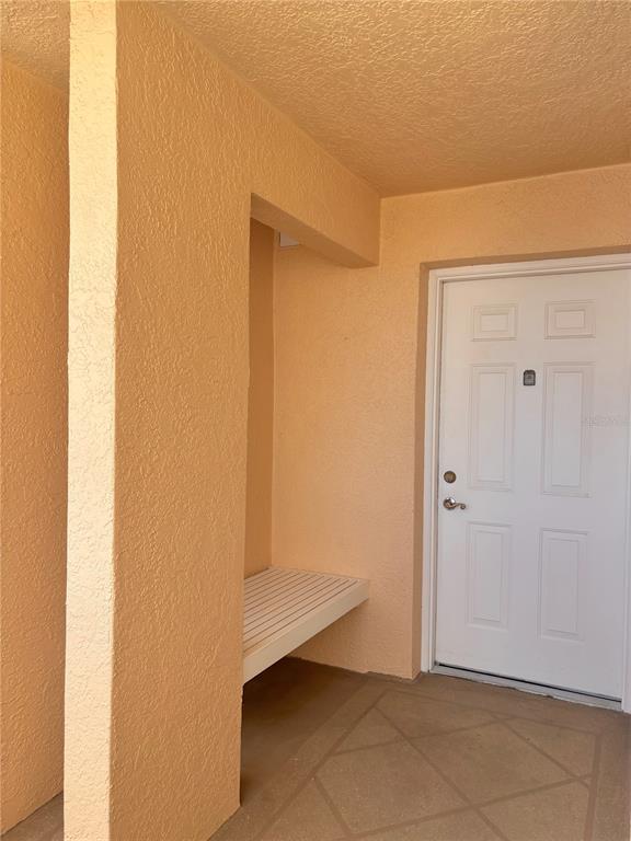A white door and a built-in bench are located on a covered outdoor entryway — 4460 FAIRWAYS BOULEVARD UNIT 407, BRADENTON, FL
