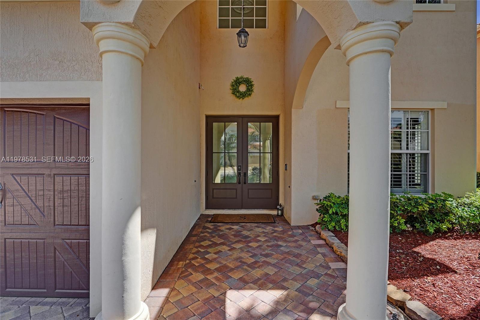 A living room with a blue sectional sofa, area rug, and an open kitchen — 3402 Vanderbilt Dr, Wellington FL 33414, WELLINGTON, FL