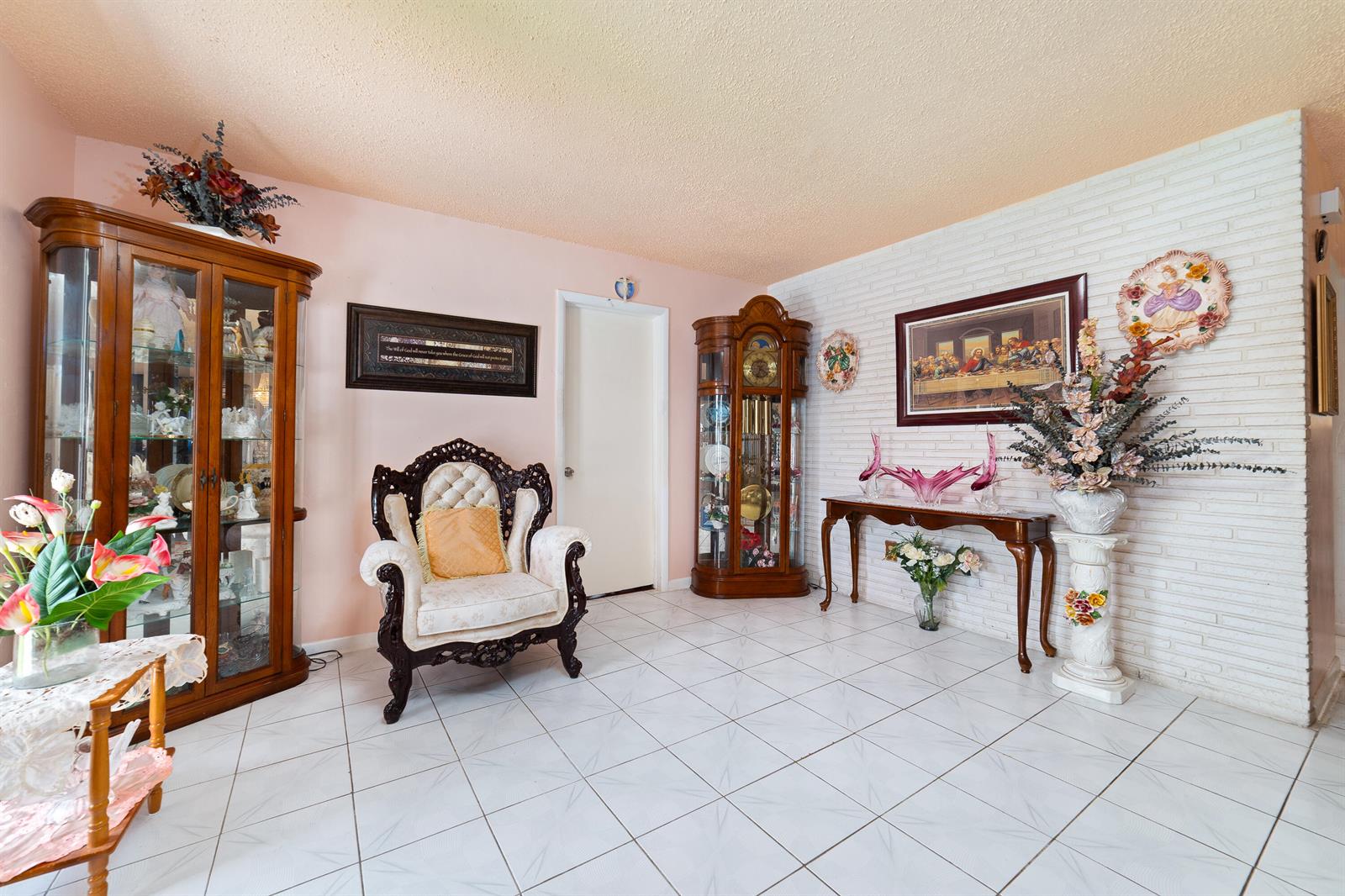 A living room features white tile floors, a brick wall, a grandfather clock, and display cabinets — 4460 NW 3rd Place, Plantation FL 33317, PLANTATION, FL