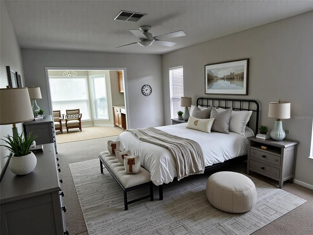 A bedroom features a metal bed frame, gray furniture, a bench, and an adjacent sitting area — 1225 GILLESPIE DRIVE N, PALM HARBOR, FL