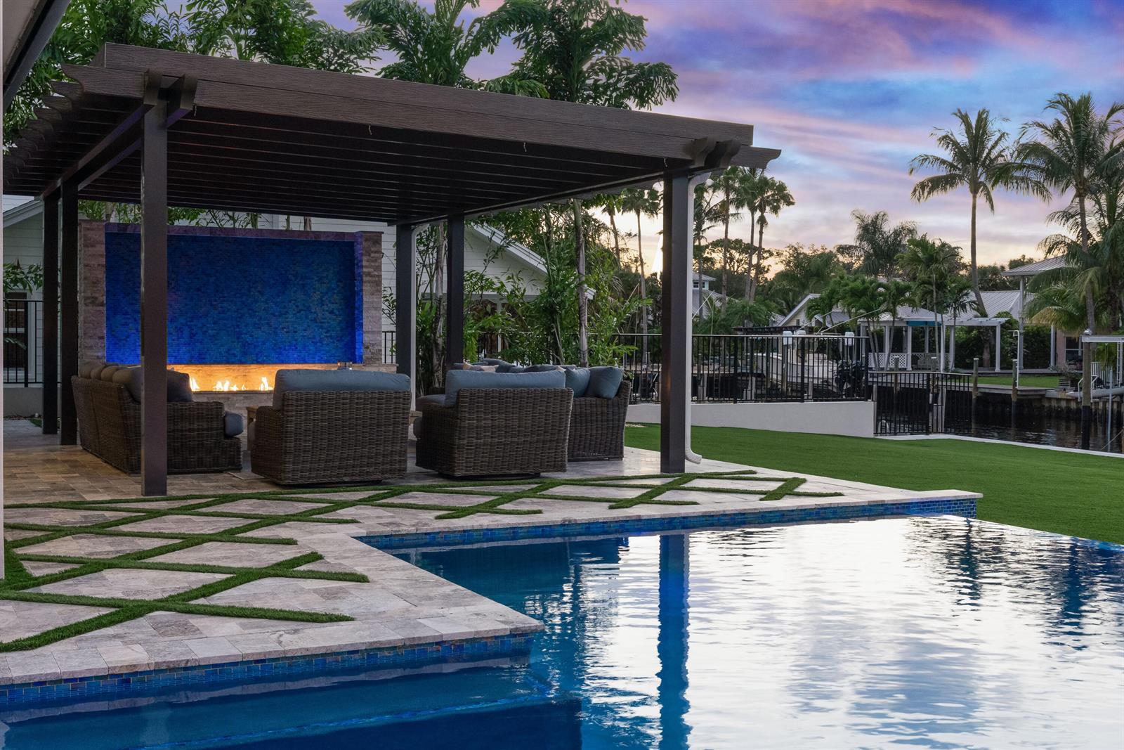 A backyard patio features a pergola, fire feature, pool, and artificial turf inlay pavers — 261 Old Jupiter Beach Road, Jupiter FL 33477, JUPITER, FL