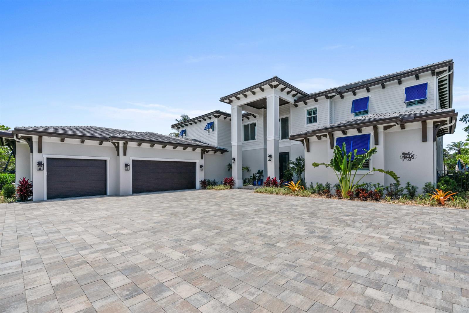A two-story house with a paved driveway, a three-car garage, and blue window shutters — 261 Old Jupiter Beach Road, Jupiter FL 33477, JUPITER, FL