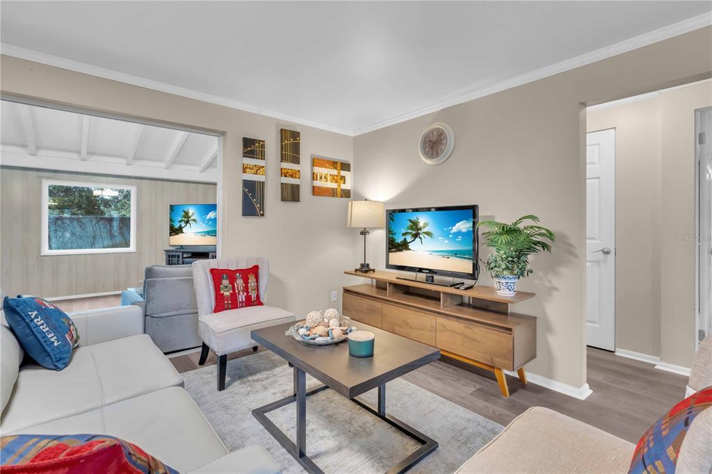 A living room features a light gray sofa, a coffee table, and a television console — 7420 CASS CIRCLE, SARASOTA, FL