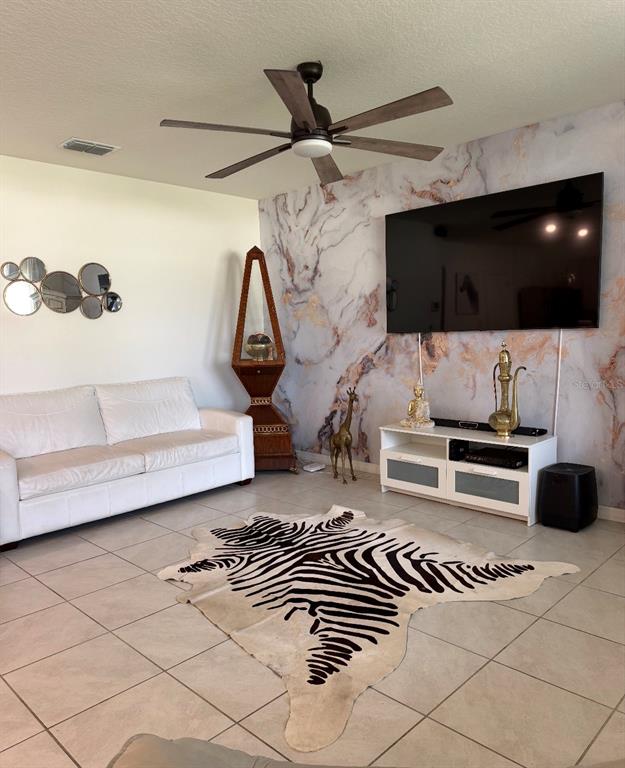 A living room features a marble-patterned accent wall, a white sofa, and a zebra-print rug — 5240 GREENHEART AVENUE, MOUNT DORA, FL