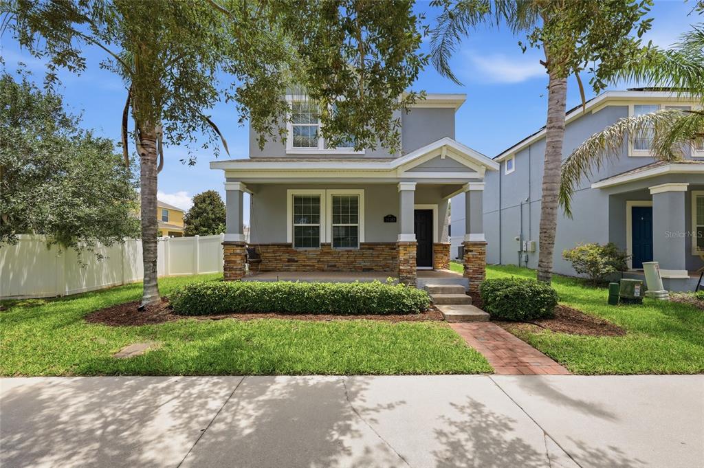 A two-story house with a stone-accented front porch and a white vinyl fence — 15183 BRIDGEWATER CROSSINGS BOULEVARD, WINTER GARDEN, FL