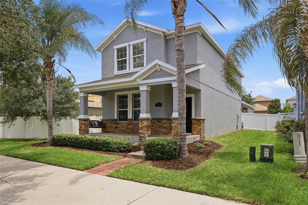 A two-story gray house with a stone-accented front porch and a palm tree — 15183 BRIDGEWATER CROSSINGS BOULEVARD, WINTER GARDEN, FL