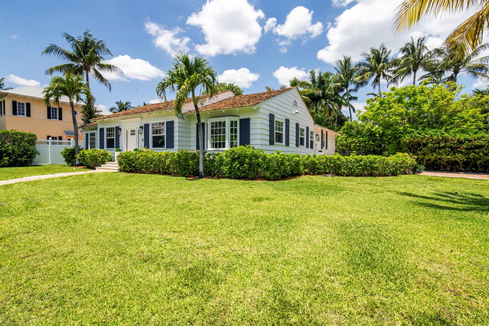 A white single-story house with dark shutters and a shingled roof sits behind a lawn — 1017 Tamarind Road, Delray Beach FL 33483, DELRAY BEACH, FL