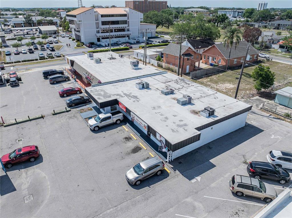 An aerial view shows a commercial building with a flat roof and an adjacent parking lot — 211 E CENTRAL AVENUE, WINTER HAVEN, FL