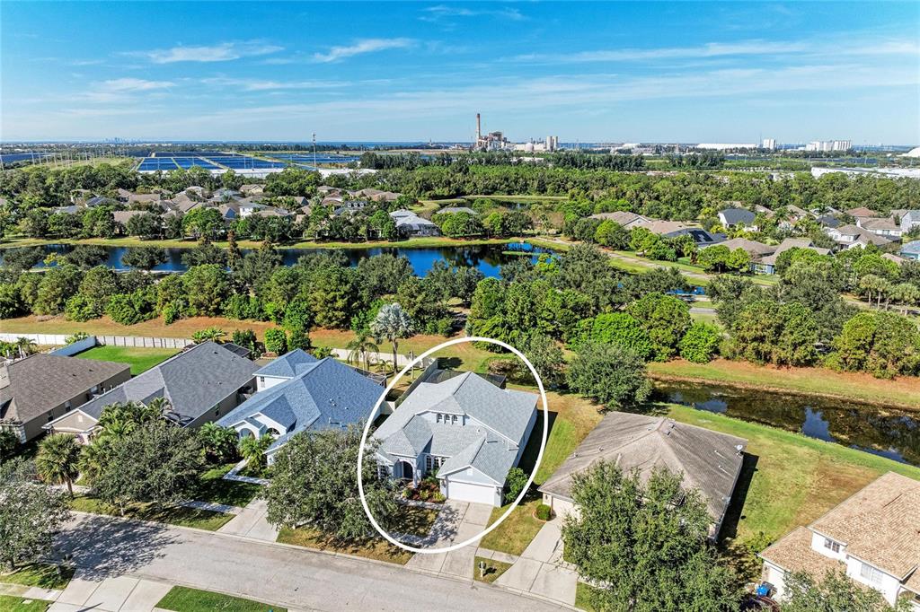 An aerial view shows a single-story house with a gray roof in a suburban neighborhood — 7114 CROMWELL PARK LANE, APOLLO BEACH, FL