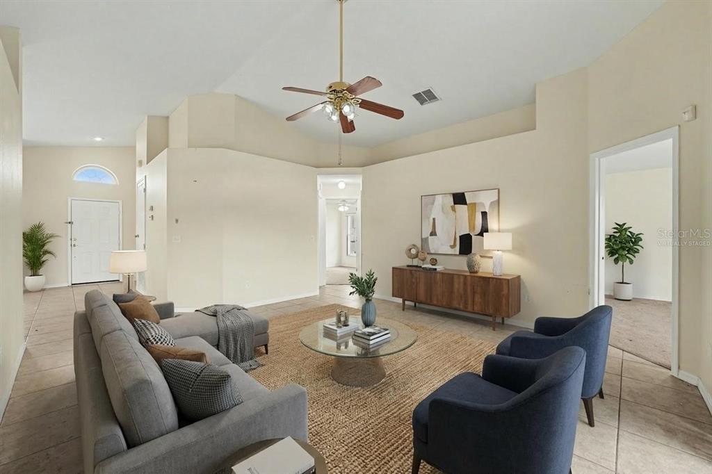 A living room with tile floors, a ceiling fan, and a neutral color palette — 162 CANARY ISLAND CIRCLE, DAVENPORT, FL