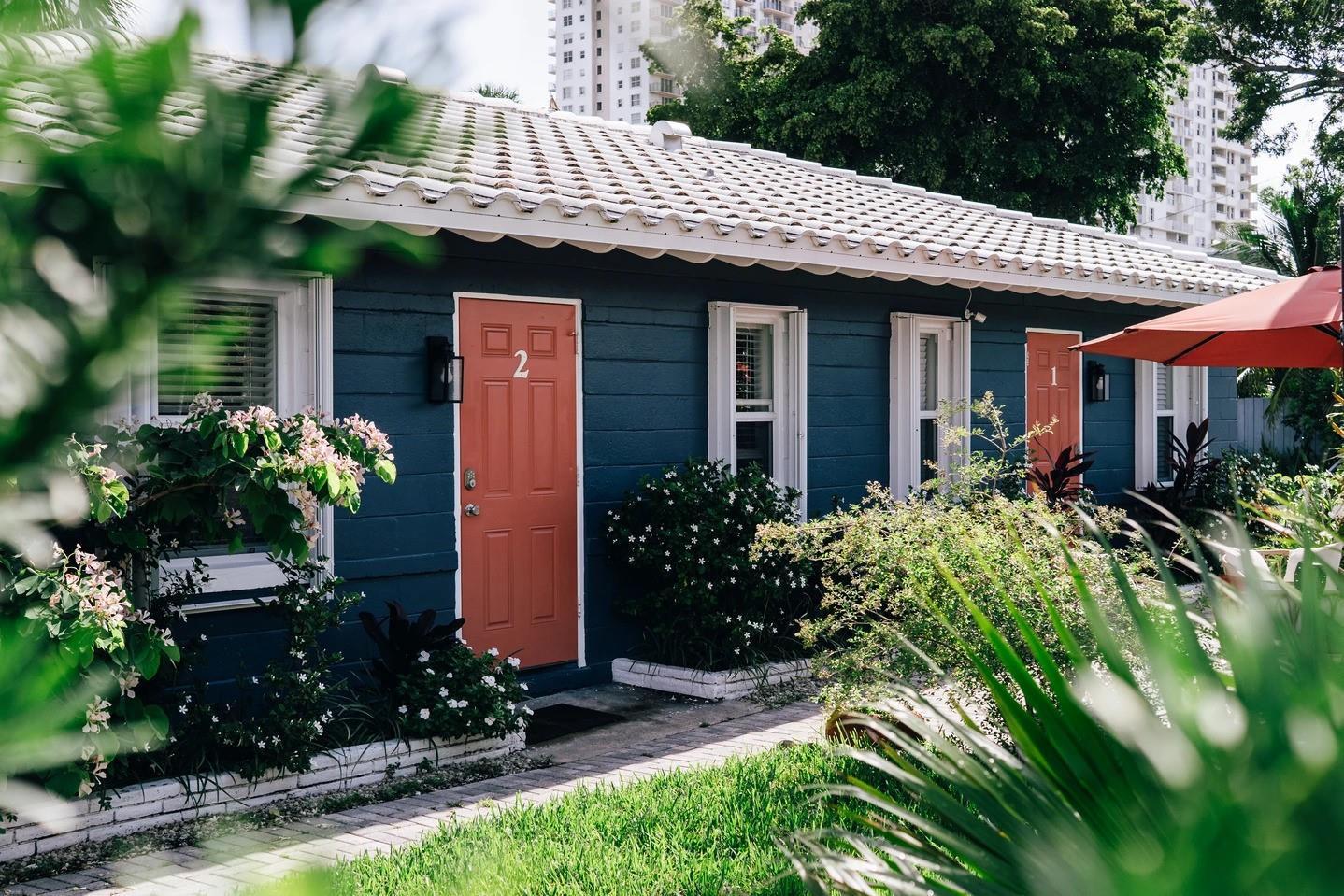 A blue exterior building features two orange doors numbered one and two with white trim — 213 Hibiscus Avenue, Pompano Beach FL 33062, POMPANO BEACH, FL