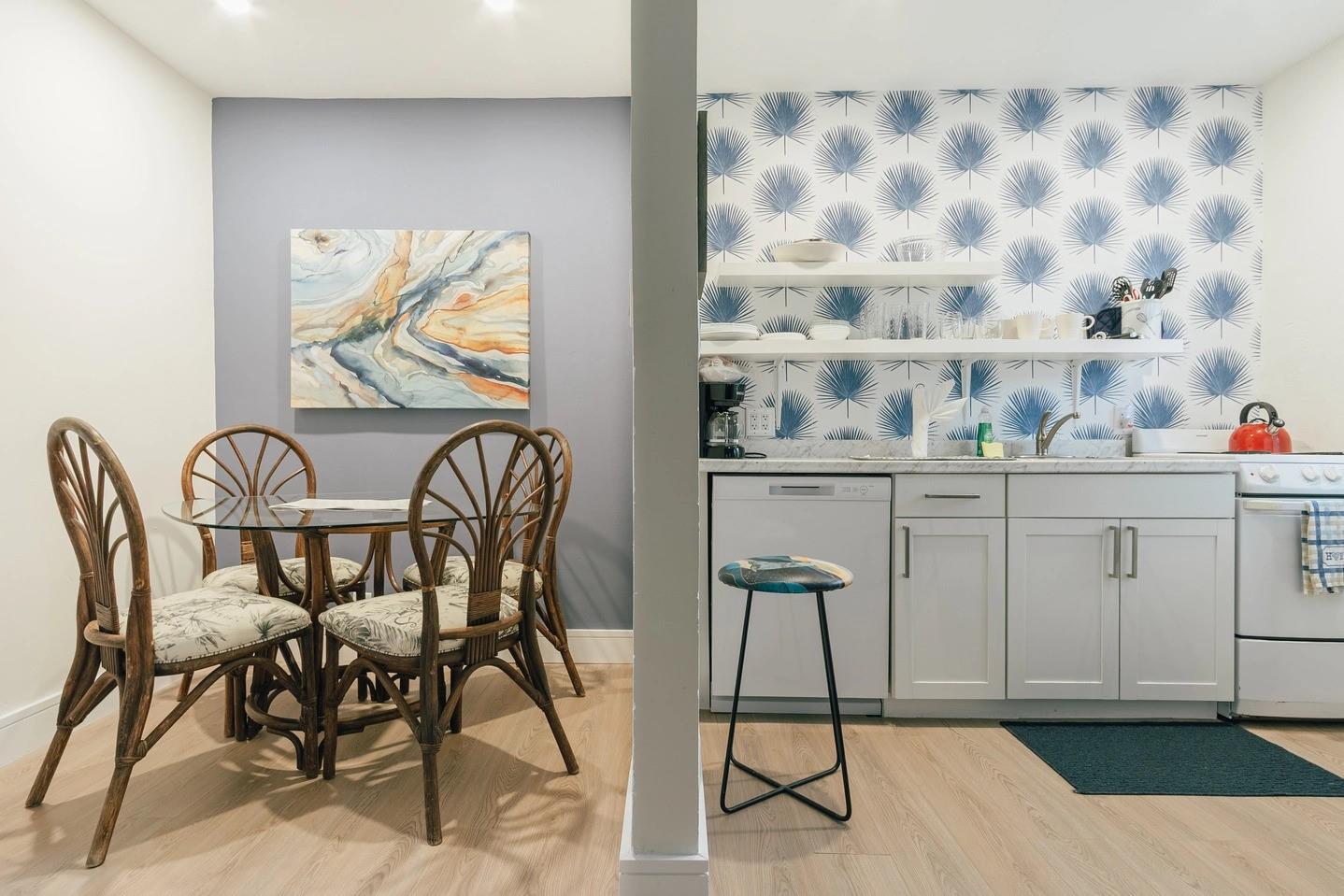 A dining area with a glass table and rattan chairs next to a small kitchen — 213 Hibiscus Avenue, Pompano Beach FL 33062, POMPANO BEACH, FL