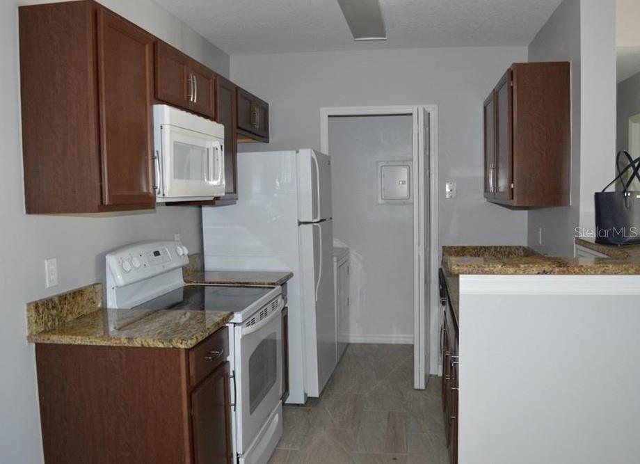 A room with light tile flooring, a large window with blinds, and a sliding glass door — 4360 S KIRKMAN ROAD UNIT 408, ORLANDO, FL