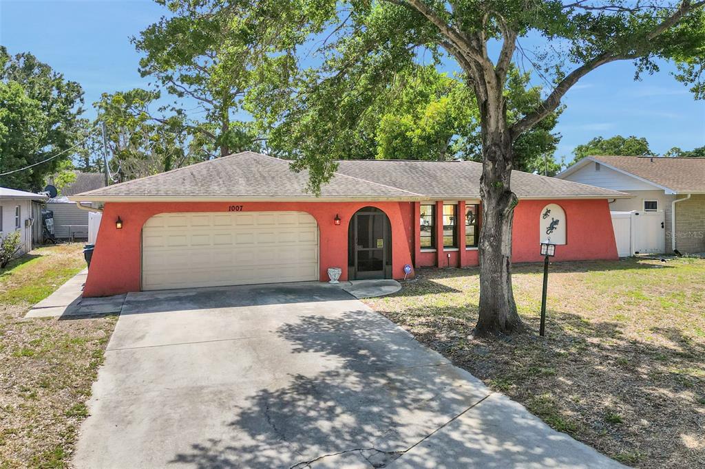 An aerial view shows a single-story house with a fenced backyard and mature trees — 1007 22ND AVENUE W, PALMETTO, FL