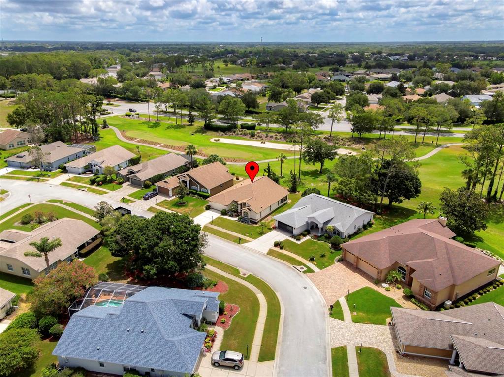 An aerial view shows a residential neighborhood with houses bordering a golf course — 11228 WINDRUSH CIRCLE, HUDSON, FL