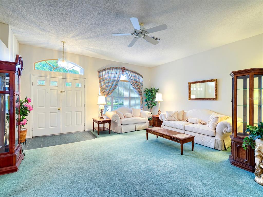 A kitchen and dining area with floral wallpaper, white cabinets, and blue tile flooring — 11228 WINDRUSH CIRCLE, HUDSON, FL