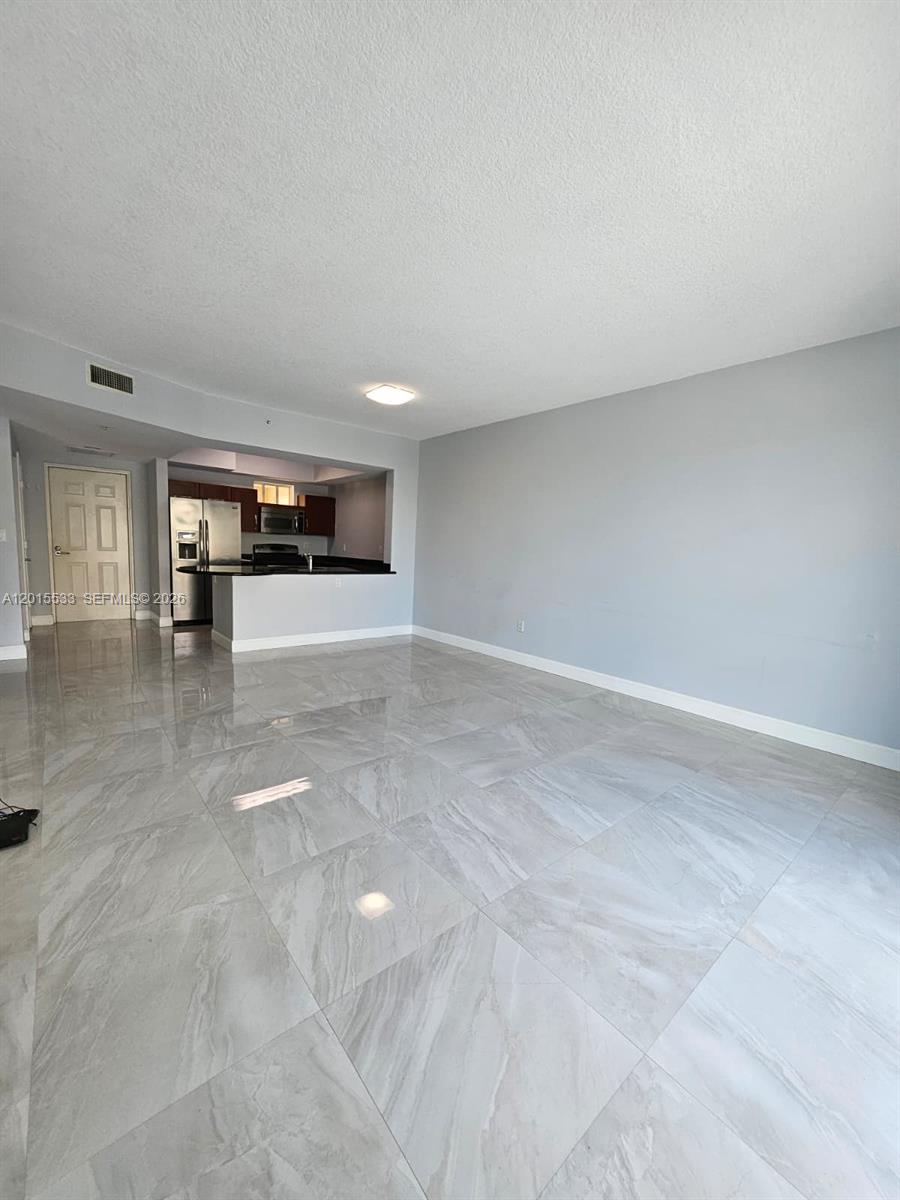 An open-concept living area features light gray walls and large, polished marble-look floor tiles — 7270 SW 88th St # B202, Miami FL 33156, MIAMI, FL