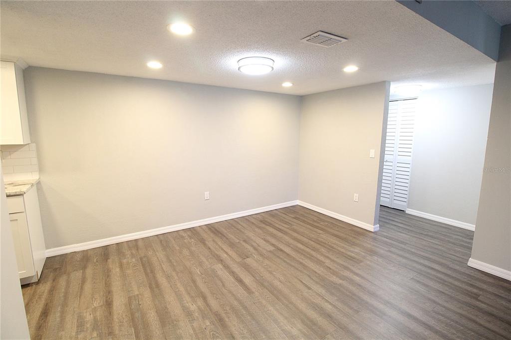 A dining area features light gray walls, wood-look flooring, recessed lighting, and a ceiling fixture — 4119 61ST AVENUE TERRACE W UNIT 407, BRADENTON, FL