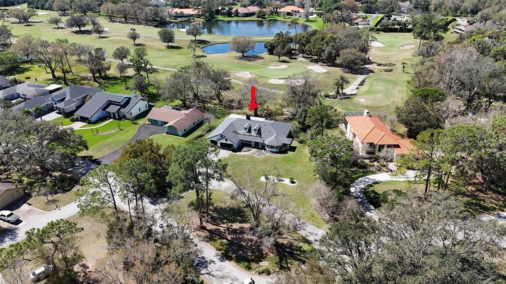 An aerial view shows a house with a dark roof situated on a golf course — 5331 SADDLEBROOK WAY, WESLEY CHAPEL, FL
