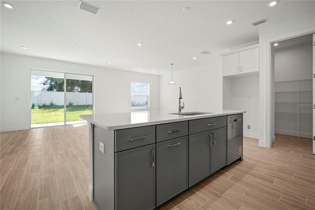 A kitchen island with dark gray cabinets and a white countertop sits in a room — 2949 STEWART CREEK CIRCLE, PLANT CITY, FL