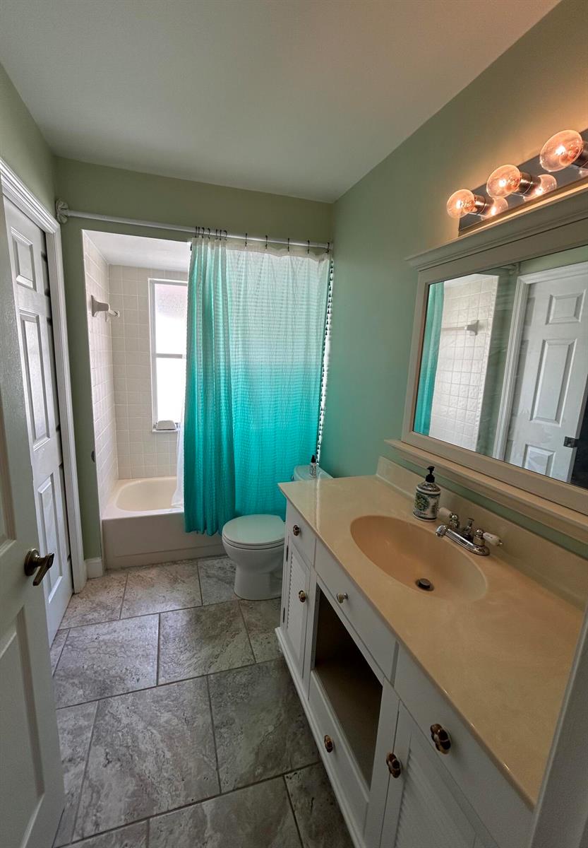 A bathroom features a vanity with a beige countertop, a toilet, and a shower-tub combination — 6376 Breckenridge Circle, Lake Worth FL 33467, LAKE WORTH, FL