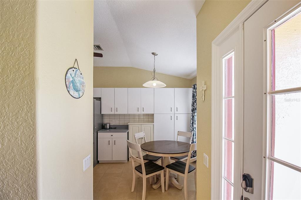 A dining area features white cabinetry, a round wooden table, and four chairs — 1465 SHIELDS STREET, PUNTA GORDA, FL