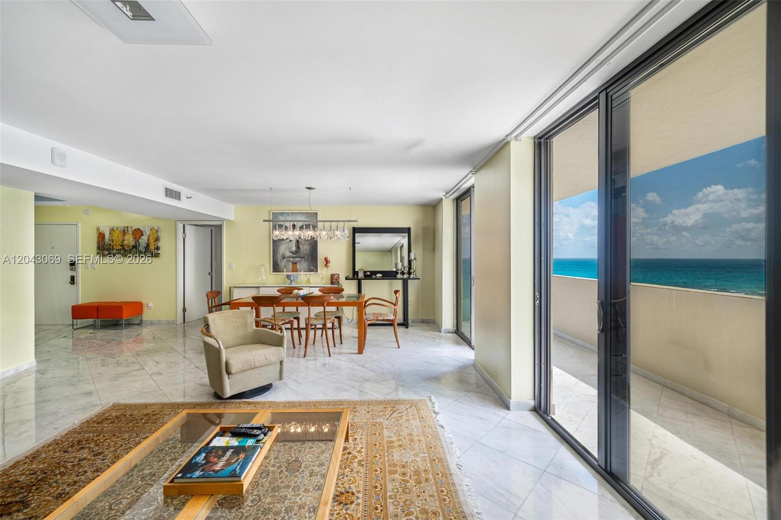 A dining and living area features marble floors, a glass-topped table, and a balcony view — 1623 Collins Ave, Miami Beach FL 33139, MIAMI BEACH, FL