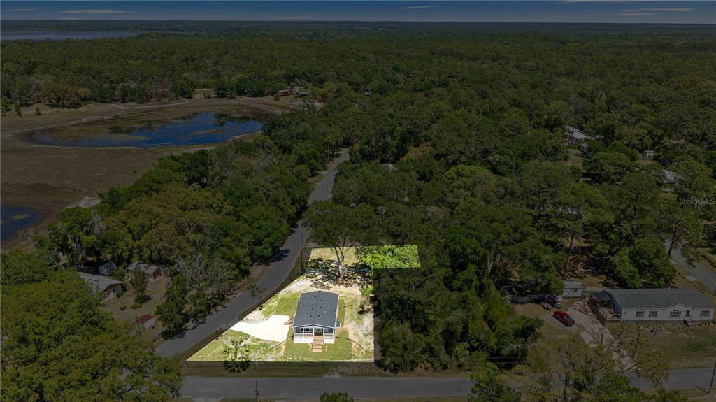 An aerial view shows a single-story house on a lot surrounded by trees and vegetation — 17360 SE 65TH STREET, OCKLAWAHA, FL