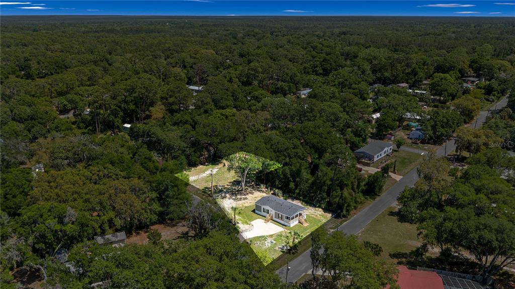 An aerial view shows a single-story house situated on a partially cleared, wooded lot — 17360 SE 65TH STREET, OCKLAWAHA, FL