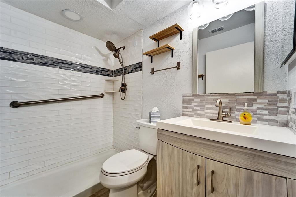 A bathroom features a white subway tile shower, a vanity, and a toilet — 8330 HIGH POINT CIRCLE UNIT 6, PORT RICHEY, FL